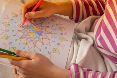 Female painting mandalas antistress page to combat stress. relaxing hobby mental wellbeing and art