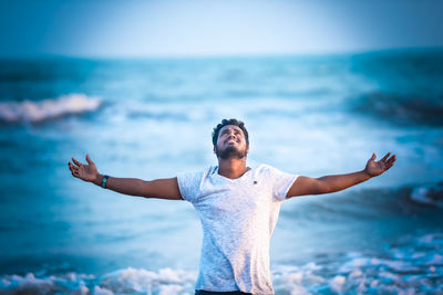 Full length of man standing at beach against sky