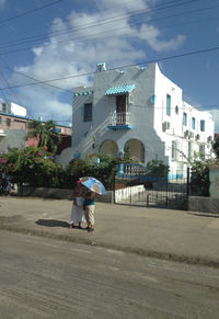 Woman walking on street against buildings in city