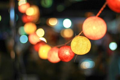 Close-up of illuminated lights hanging at night