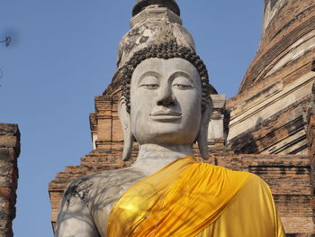 Low angle view of statue against historic building against sky