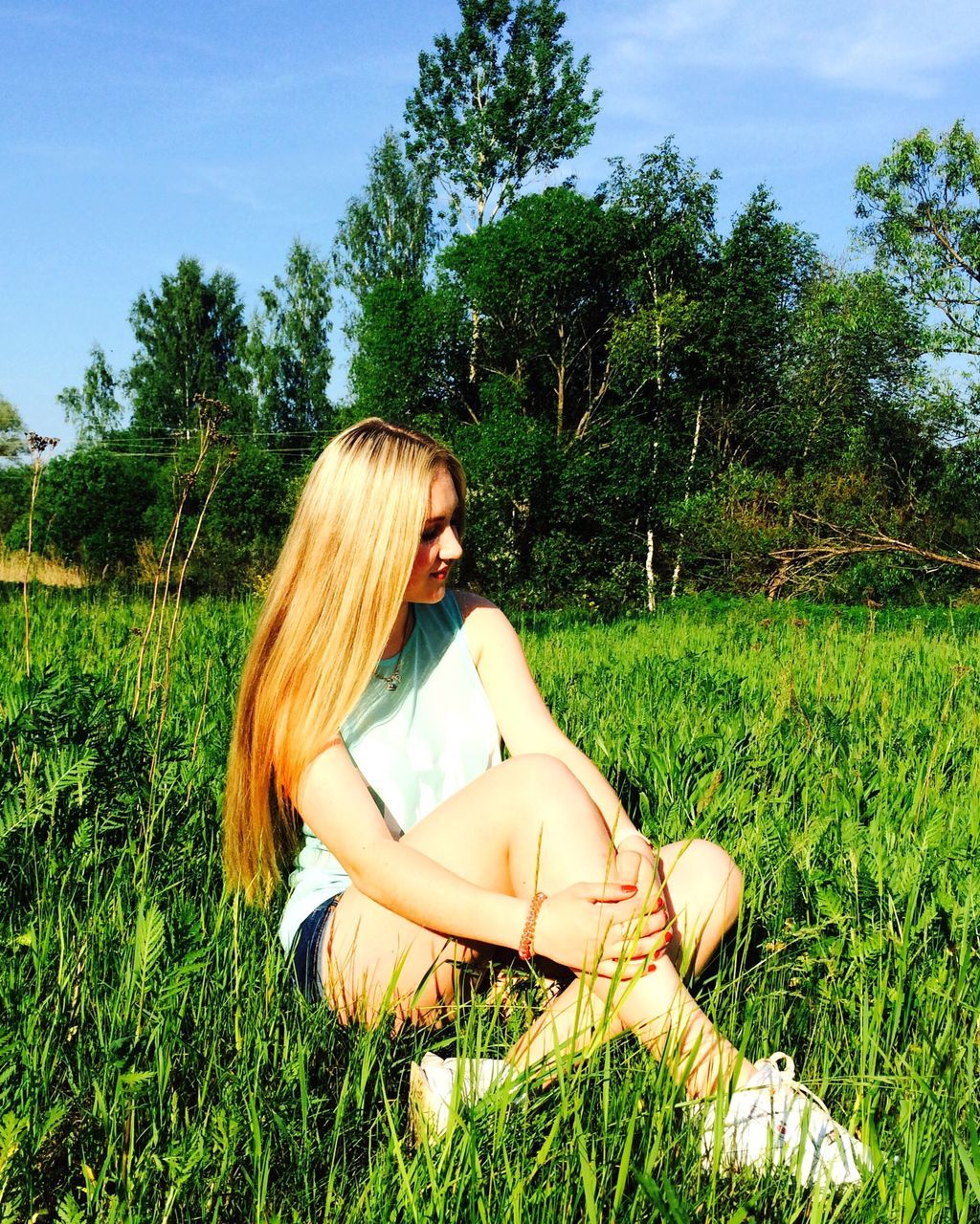 grass, grassy, field, tree, growth, tranquility, one person, sky, green color, relaxation, nature, landscape, tranquil scene, plant, outdoors, grassland, day, sunlight, park - man made space, sitting