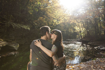 Couple standing by water at park