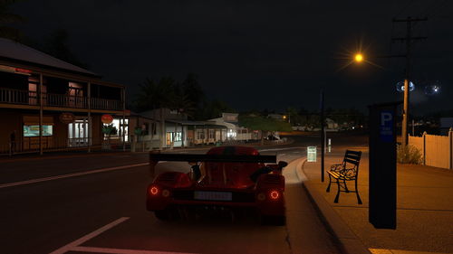 Cars on street against illuminated buildings in city at night