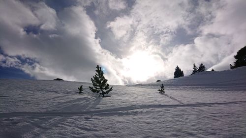 View of people skiing on snowcapped mountain against sky
