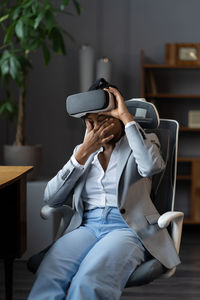 Frustrated african businesswoman unwell rub tired eyes from wearing vr goggles in office for work