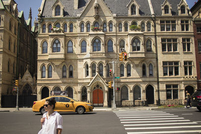 People on street against buildings in city