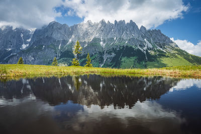 Scenic view of lake by mountains against sky