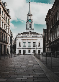 Street amidst buildings against sky in city