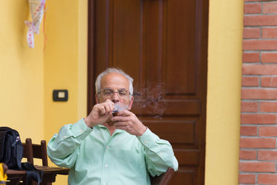 Portrait of man standing against brick wall