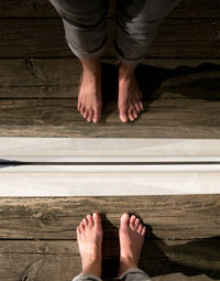 Low section of man standing on wooden floor