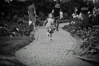 Full length of cute girl running on footpath in park