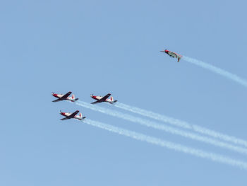 Low angle view of airshow against clear sky