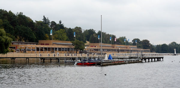 Houses by river against sky