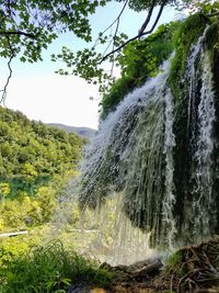 Scenic view of waterfall against sky