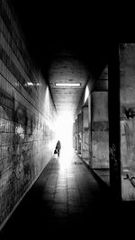 Rear view of woman walking in tunnel