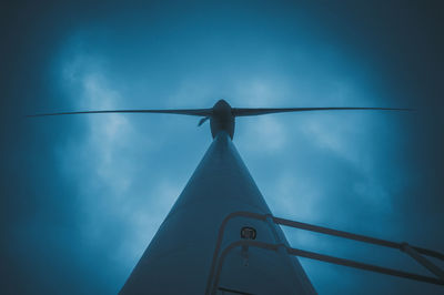 Low angle view of wind turbine against blue sky