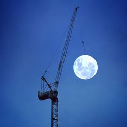 Low angle view of moon against blue sky