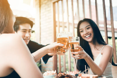 Happy young woman drinking from glass of a man