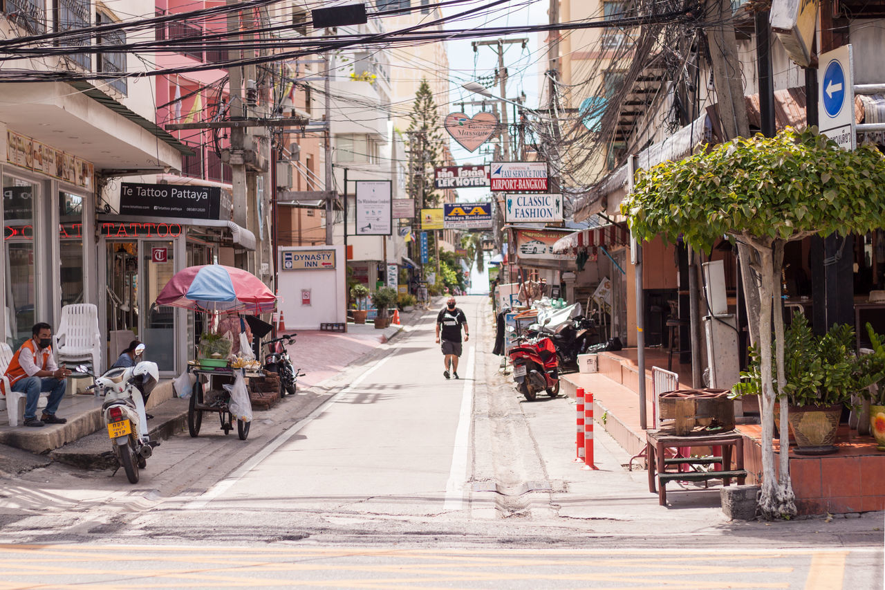 PEOPLE ON STREET AMIDST BUILDINGS IN CITY