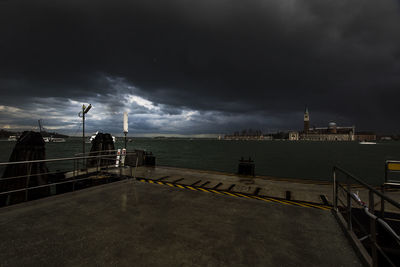 Pier over city against sky at dusk