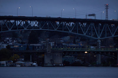 Bridge over river against sky at night