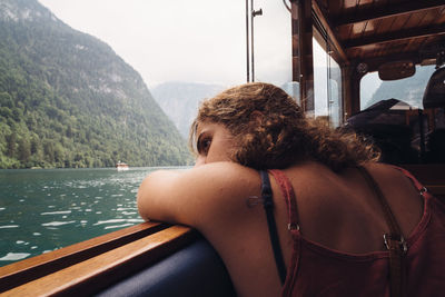 Woman sitting in boat on lake against sky