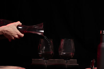 Man holding glass of red wine on table