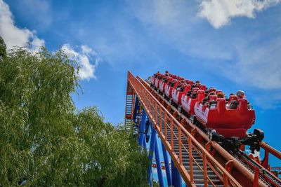 Low angle view of amusement park against blue sky