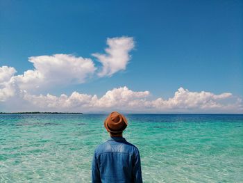 Rear view of man standing against sea