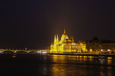 Illuminated hungarian parliament building by river at night