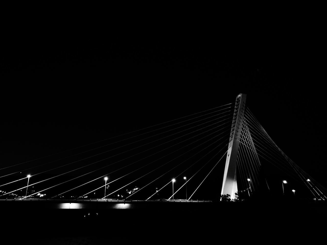 SUSPENSION BRIDGE AGAINST SKY AT NIGHT