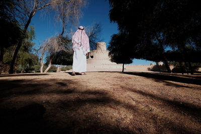 Man standing by trees against sky