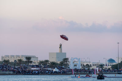 People flying over city against sky