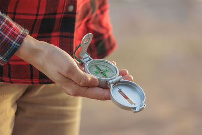 Cropped hand holding navigational compass