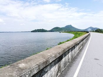 Scenic view of sea by road against sky