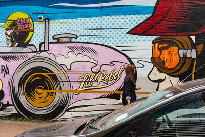 Rear view of man with graffiti on wall