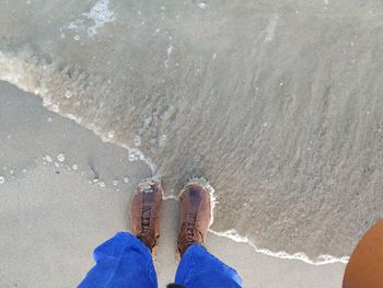 Low section of man standing at shore