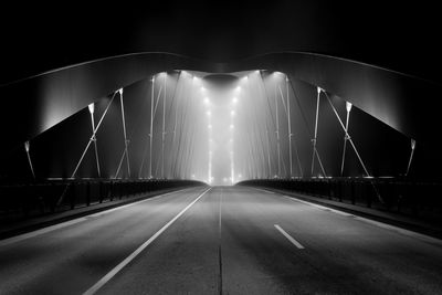 View of bridge over road at night