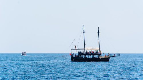 Sailboat sailing on sea against clear sky