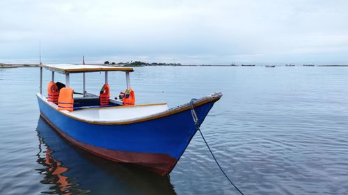 Boat moored in sea against sky