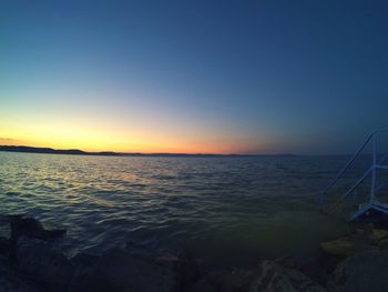 Scenic view of sea against clear sky at sunset