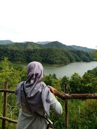 Rear view of woman looking at mountain against sky