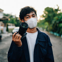 Portrait of young man holding camera