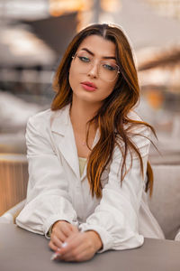 Portrait of young woman sitting on bed at home