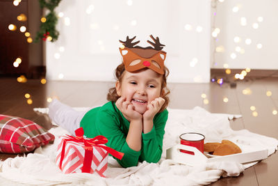 Girl lying on floor wearing mask during christmas