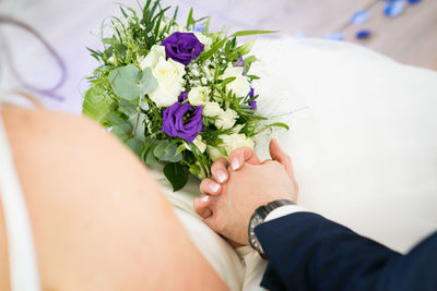 Midsection of bride holding bouquet