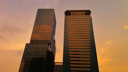 Low angle view of skyscrapers against sky during sunset