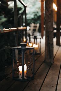 Illuminated tea light candles on table in temple