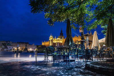 Gazebo by illuminated building against sky in city during winter